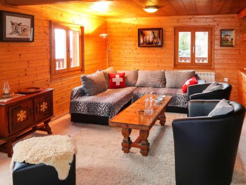 een woonkamer met een bank en een tafel bij Chalet L'aïeul by Interhome in Nendaz