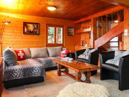 een woonkamer met een bank en een tafel bij Chalet L'aïeul by Interhome in Nendaz