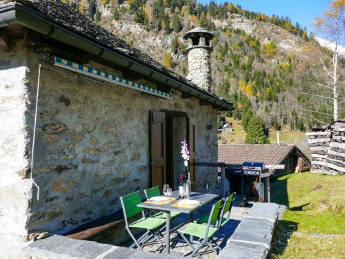ein Tisch und Stühle vor einem Gebäude in der Unterkunft Holiday Home Rustico Stübii by Interhome in Campo Blenio