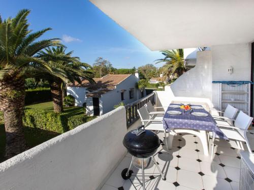 een balkon met een tafel en stoelen en palmbomen bij Apartment Ducados Golf Nat by Interhome in Pals