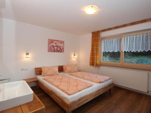 a bedroom with a bed and a sink and a window at Holiday Home Zeller by Interhome in Stummerberg