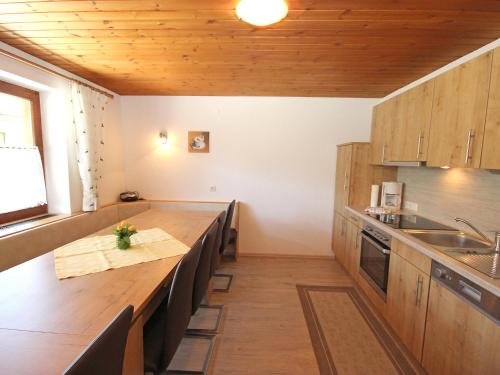a kitchen with a large wooden table and chairs at Holiday Home Zeller by Interhome in Stummerberg