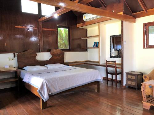 a bedroom with a bed and a table and a chair at Lam Sai village hotel in Ban Laem Sai
