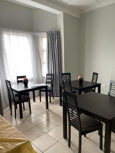 une salle à manger avec des tables et des chaises ainsi qu'une fenêtre dans l'établissement Ikhwezi guest house, à East London