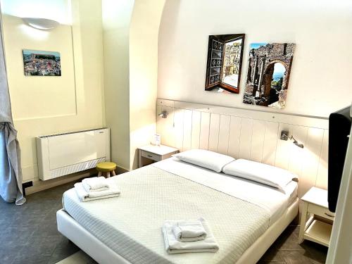 a bedroom with a bed with two towels on it at Il Giardino Falcone in Catania