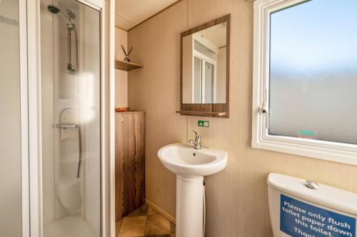 a bathroom with a sink and a toilet and a mirror at Lakeside, Thorpe Park Cleethorpes Static Caravan in Cleethorpes