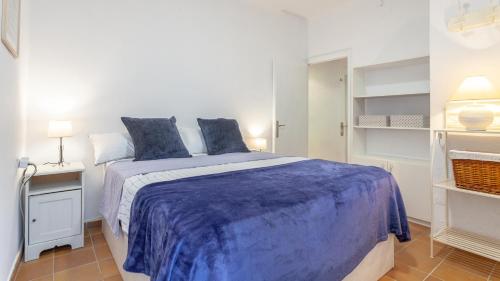 1 dormitorio con 1 cama grande con sábanas azules en ELS CANYERS en Calella de Palafrugell