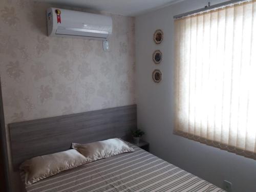 ein Schlafzimmer mit einem Bett mit einem Fenster und einem Bett sidx sidx sidx in der Unterkunft Apartamentos Brisa del Mar in Luis Correia