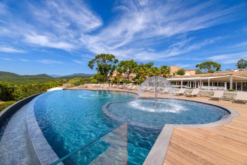 a swimming pool with a fountain in the middle at U Paesolu in Sainte-Lucie de Porto-Vecchio