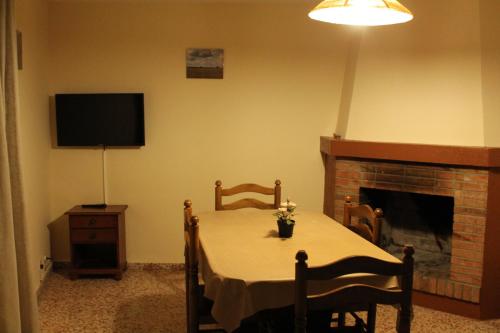 a dining room with a table and a fireplace at Apartaments Turístics Vilaró in Llorts