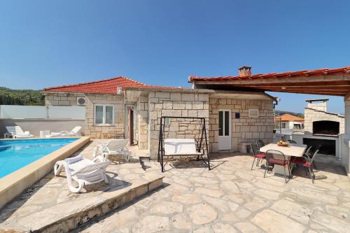 une terrasse avec une table et des chaises ainsi qu'une piscine dans l'établissement Villa Ivana, à Korčula