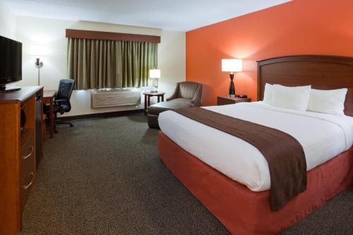 a hotel room with a large bed and a television at AmericInn by Wyndham Virginia in Virginia