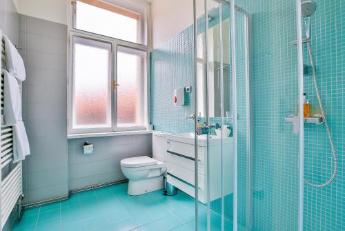 uma casa de banho com um WC e uma cabina de duche em vidro. em Apartments Embassy by LH em Praga