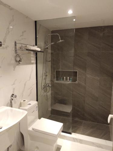 a bathroom with a shower and a toilet and a sink at Golden House Dammam in Dammam