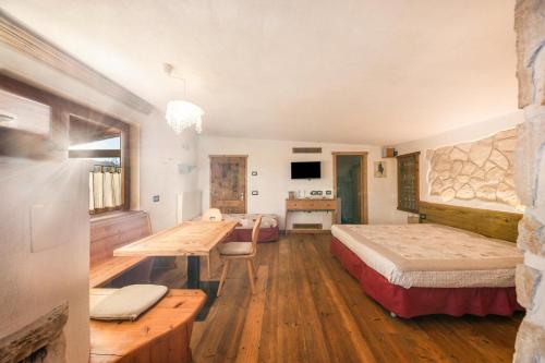 ein Schlafzimmer mit einem Bett und einem Schreibtisch in einem Zimmer in der Unterkunft La pratolina monolocale in Castello di Fiemme