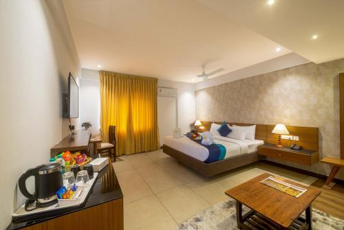 a hotel room with a bed and a table at Royal Ace Boutique Hotel in Bengaluru