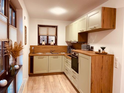 a kitchen with white cabinets and a sink at Ferienhaus Kutscherhäuschen in Eisenach