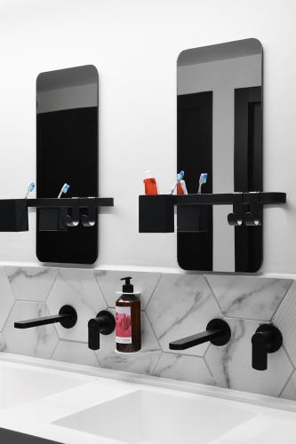 a bathroom counter with a sink and two mirrors at ISLA Tel Aviv in Tel Aviv