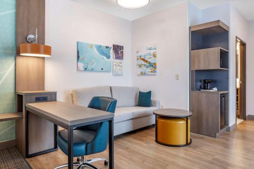a living room with a table and a couch at Comfort Suites Cottage Grove-Madison in Cottage Grove