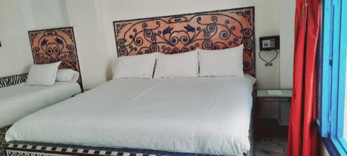 a bedroom with a white bed with a red headboard at Hotel Moroccan House Casablanca in Casablanca