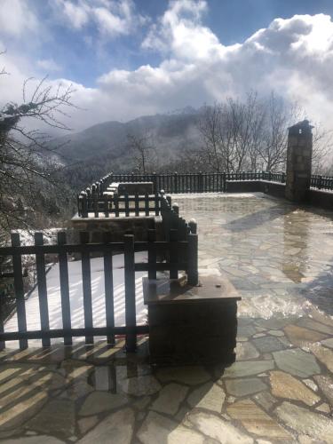 a fence on a patio with a view of a mountain at Ξενώνας Πατρικό in Neraïdochóri