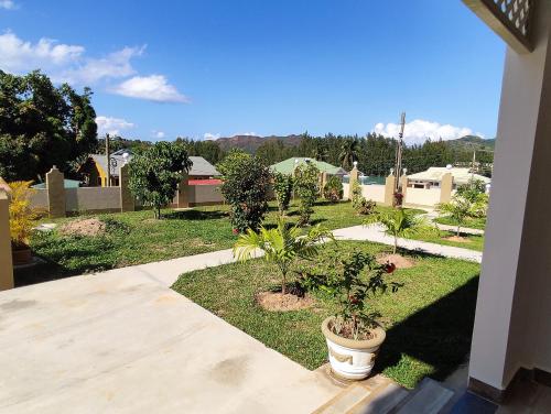 a yard with two potted plants on the grass at La Residence D'Almee Guesthouse in Anse Possession