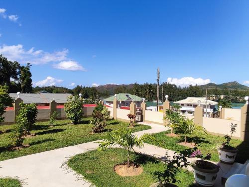 a garden with trees and plants in a yard at La Residence D'Almee Guesthouse in Anse Possession
