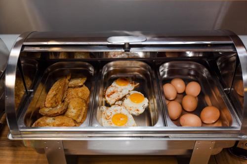 a toaster oven with eggs and bread and other foods at Penzion Hviezda in Bratislava