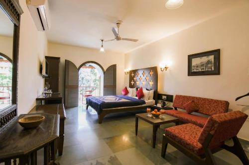 a living room with a couch and a bed at Heritage Khirasara Palace in Rajkot