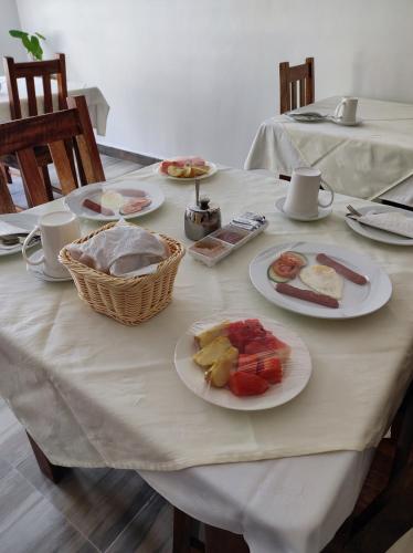 a white table with plates of food on it at La Residence D'Almee Guesthouse in Anse Possession