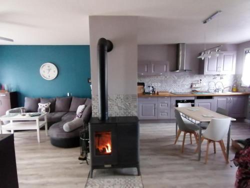 a living room with a fireplace and a couch and a table at Maison gai séjour à Bellac in Bellac