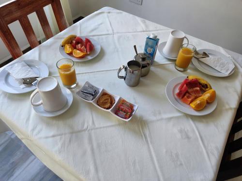 a white table with breakfast foods and drinks on it at La Residence D'Almee Guesthouse in Anse Possession