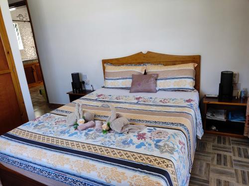 a bedroom with a bed with stuffed animals on it at La Residence D'Almee Guesthouse in Anse Possession