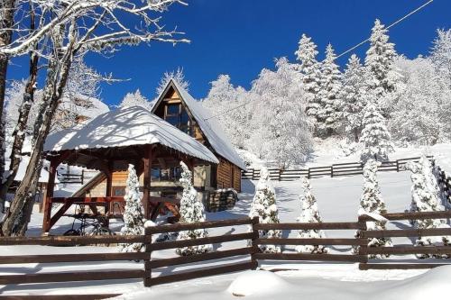a cabin in the snow with a fence at Planinska Koliba ABA-TARA in Bajina Bašta