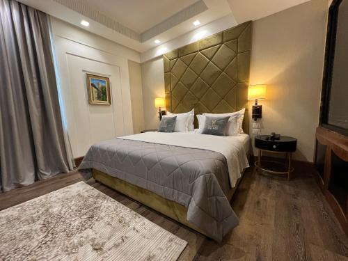 a bedroom with a large bed with a large headboard at Hotel Golden Palace in Shkodër