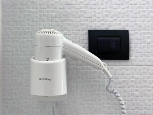 a white hairdryer is hanging on a wall at Blue Tao Beach Hotel - SHA Plus in Koh Tao