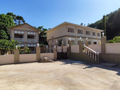 a large house with a fence and a driveway at La Residence D'Almee Guesthouse in Anse Possession