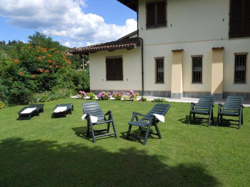 a group of chairs sitting in the grass near a building at La Cascina Di Villa Due in Narzole