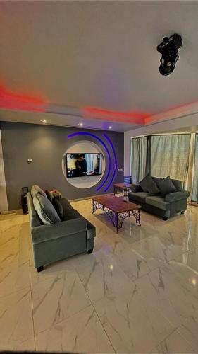 a living room with two couches and a tv at درة العروس فيلا الازرق بيتش in Durat  Alarous