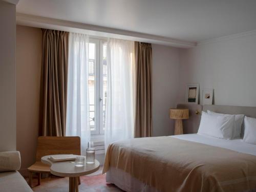 um quarto de hotel com uma cama e uma janela em Nuage em Paris