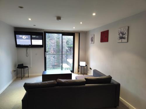 salon z kanapą i dużym oknem w obiekcie Cornhill Apartment by Serviced Living Liverpool w Liverpoolu