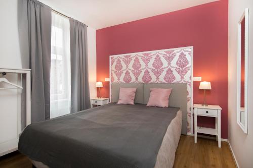 a bedroom with a large bed with pink walls at Cozy apartments in Ljubljana
