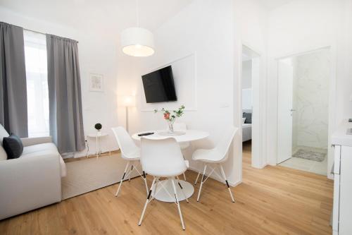 a white living room with a white table and chairs at Cozy apartments in Ljubljana