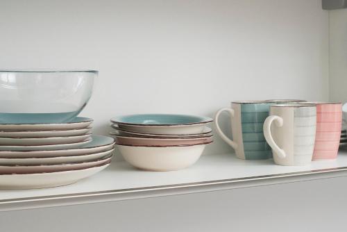a shelf with bowls and plates on it at Cozy apartments in Ljubljana