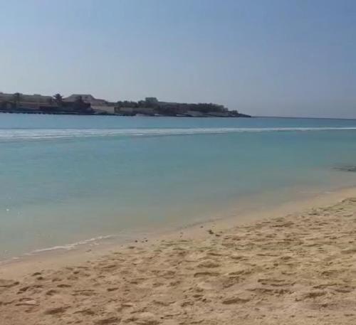 a sandy beach with the ocean in the background at درة العروس فيلا الازرق بيتش in Durat  Alarous