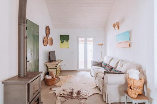 a living room with a couch and a stove at Cá Estamos ~ Hortacasa Portugal in Santiago do Cacém
