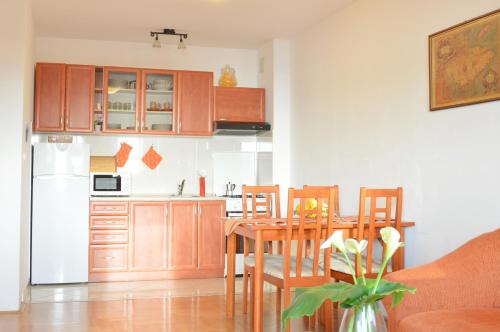 a kitchen with a wooden table and a kitchen with a refrigerator at Apartment Riva sea view in Umag