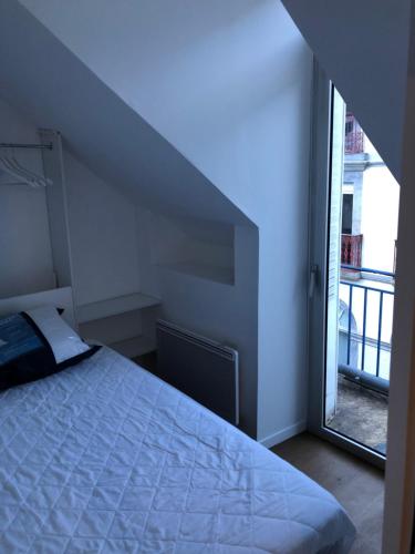 a bedroom with a bed and a large window at Appart 6 pers rénové en plein cœur de Cauterets in Cauterets