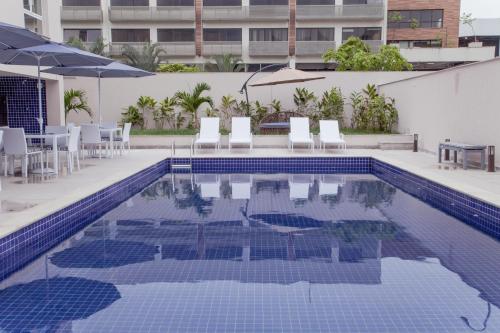 una piscina con sillas, mesa y sombrilla en Americas Townhouse Hotel, en Río de Janeiro