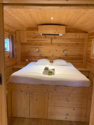 - un grand lit dans une chambre en bois dans une cabine dans l'établissement Rives Nature, à La Gacilly